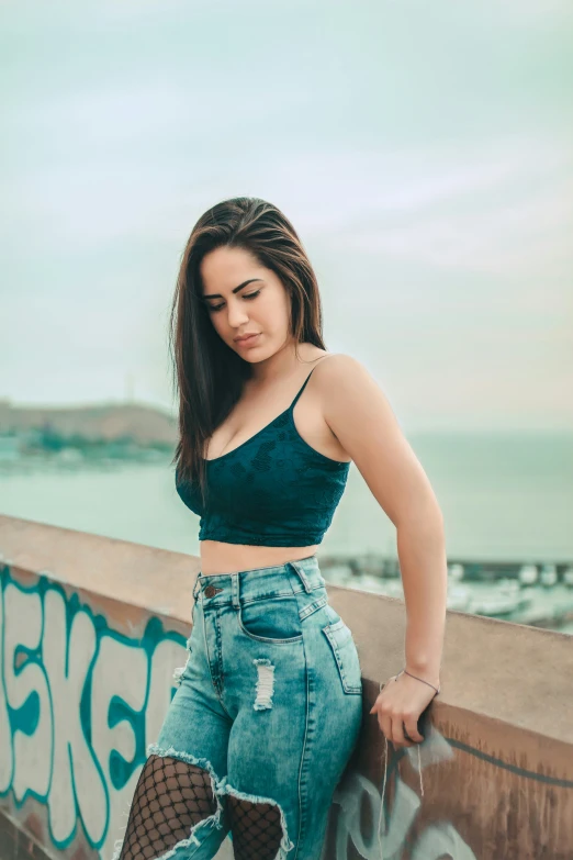 a woman posing for a po leaning against a wall