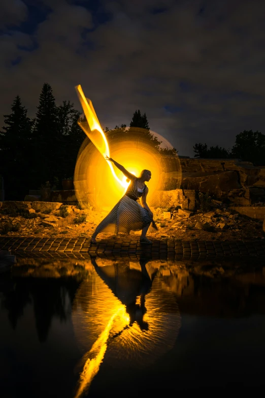 a woman dancing in front of a fire and water display