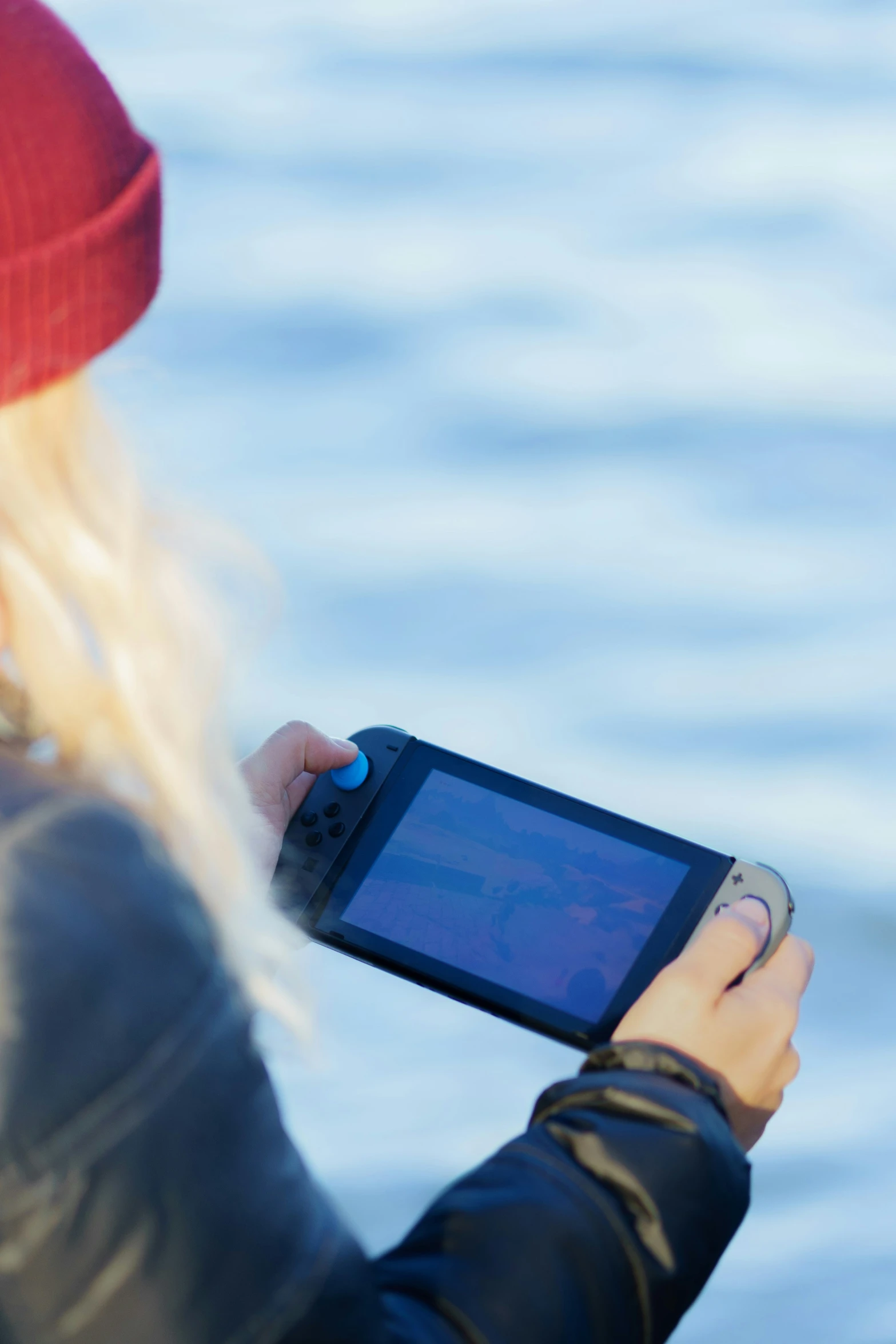 a woman in a red hat looking at a cell phone