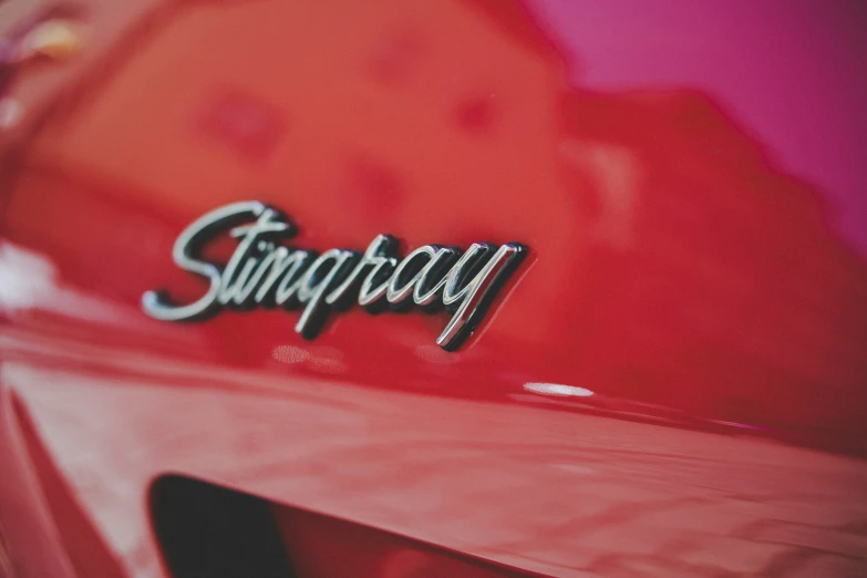 a red car with the word pography written in cursive writing on the side of it