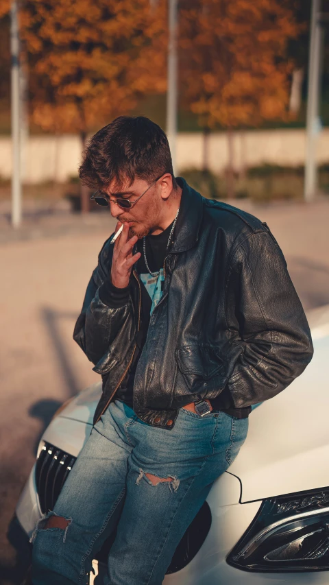 a man smoking a cigarette in front of his car