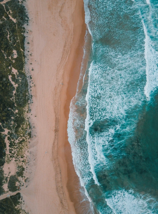 aerial po of an ocean, beach and sand