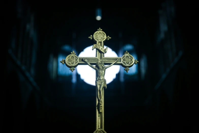 a golden crucifix stands against a dark backdrop