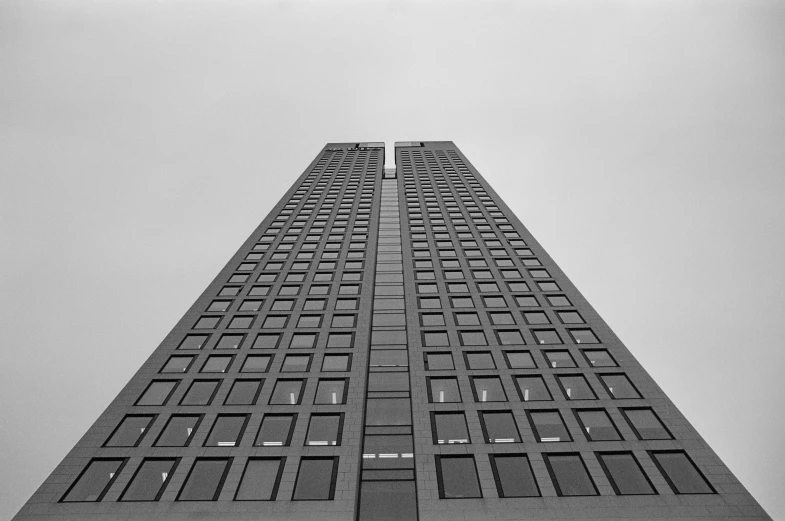a black and white po of an upward view of a tall skyscr