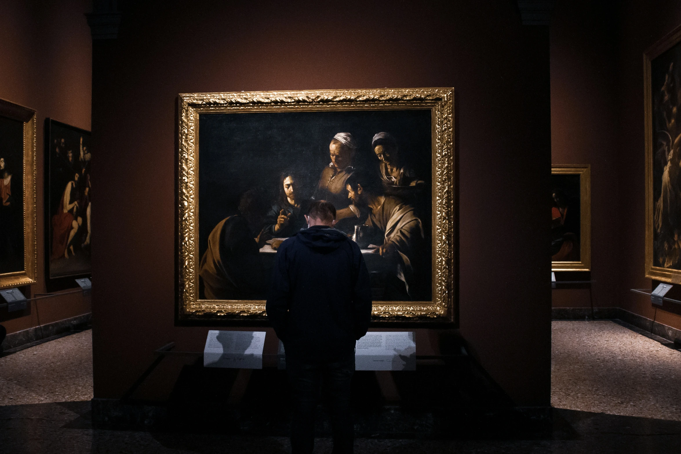 a woman standing in front of some paintings