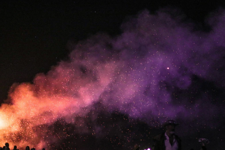 several people standing in front of a purple and red fireer