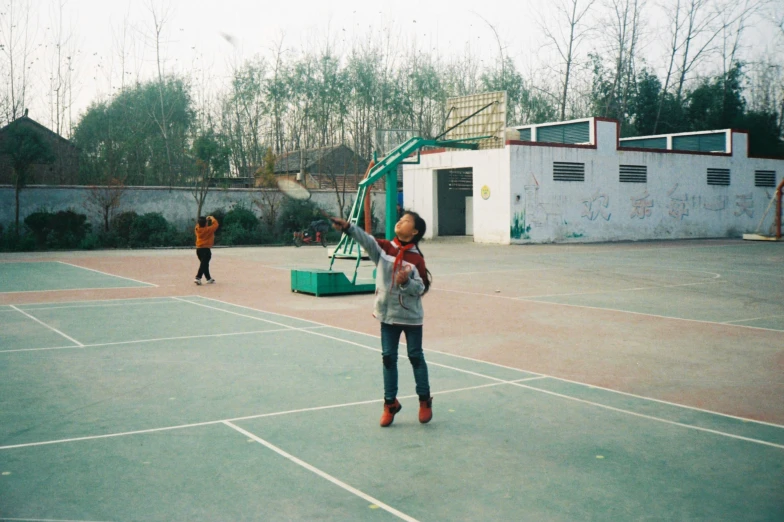 young children are playing a basketball game on an outdoor court