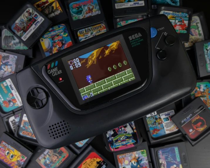 a handheld device sitting on top of a pile of games