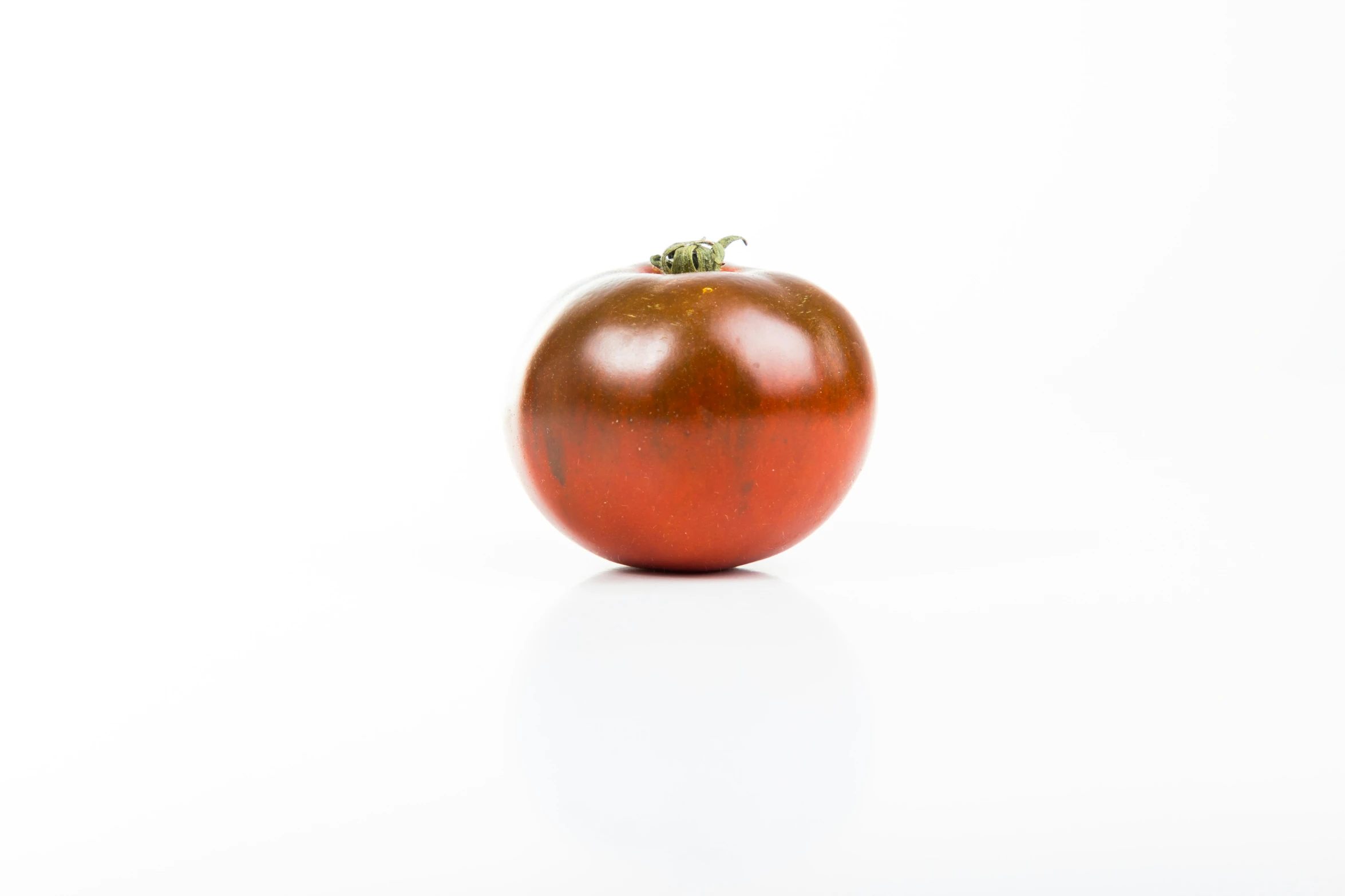 an apple sits on top of the white surface