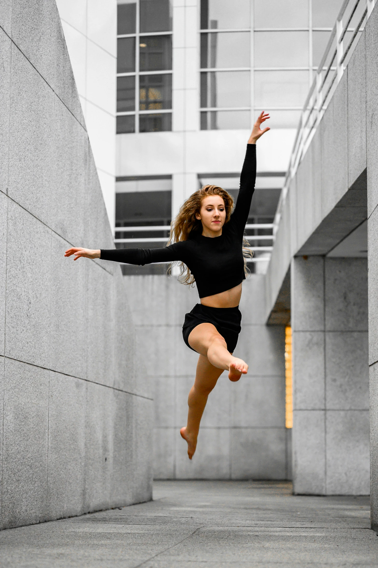 a young woman jumps in the air wearing black clothing