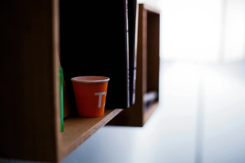 a coffee cup sitting on top of a shelf