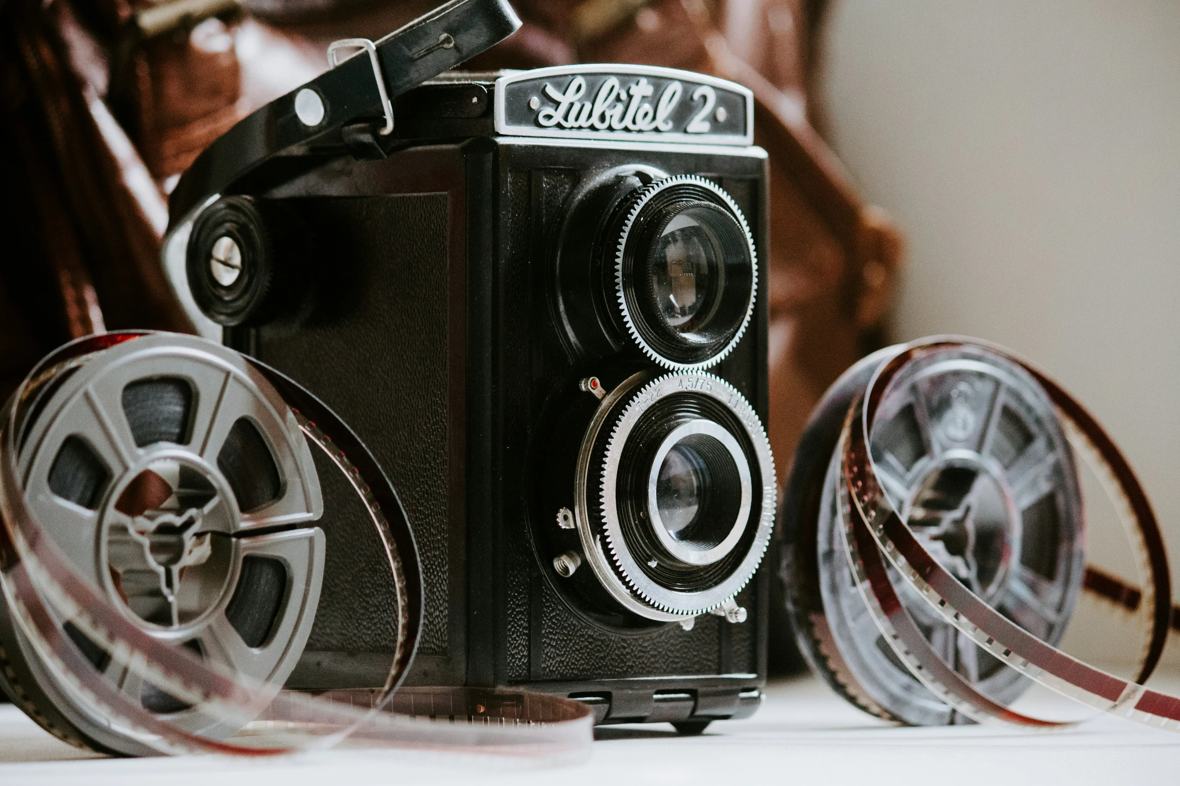 an old black camera with film strips lying on top