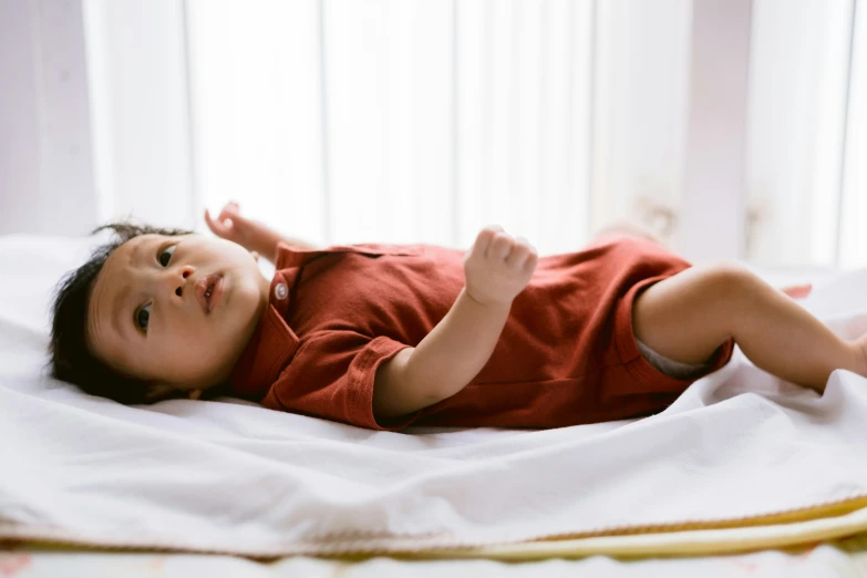 a little boy is lying on a blanket looking up at soing