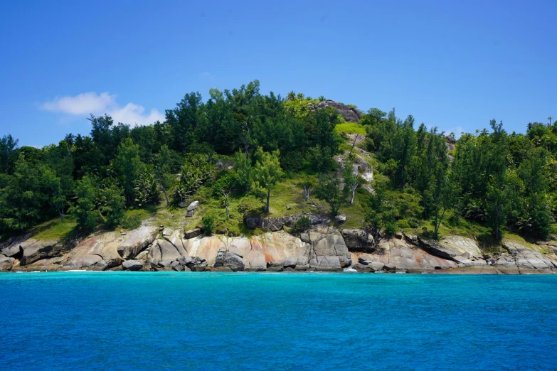 an island on the ocean with several trees in the background