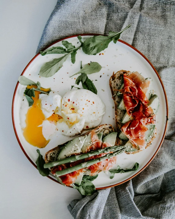 a plate of food with an egg and asparagus