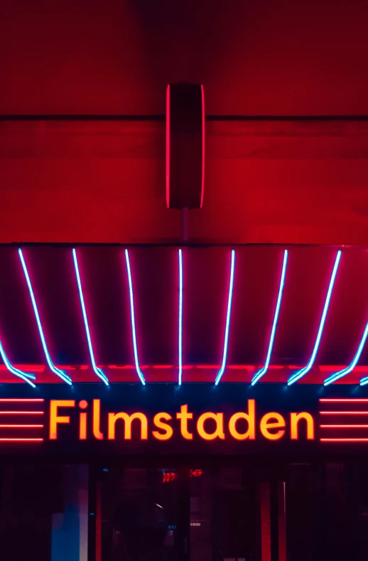 a neon sign for filmstation on the side of a building