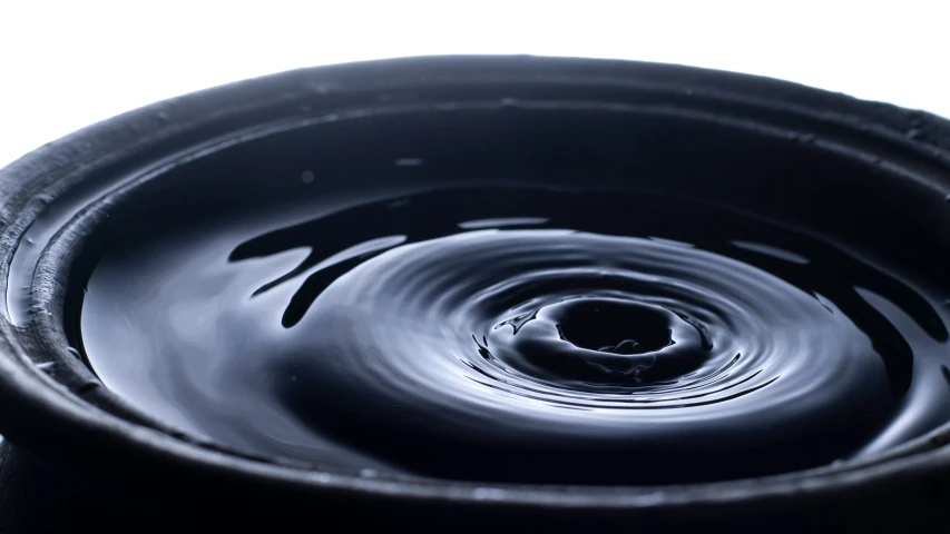 the water is falling down to a black pot