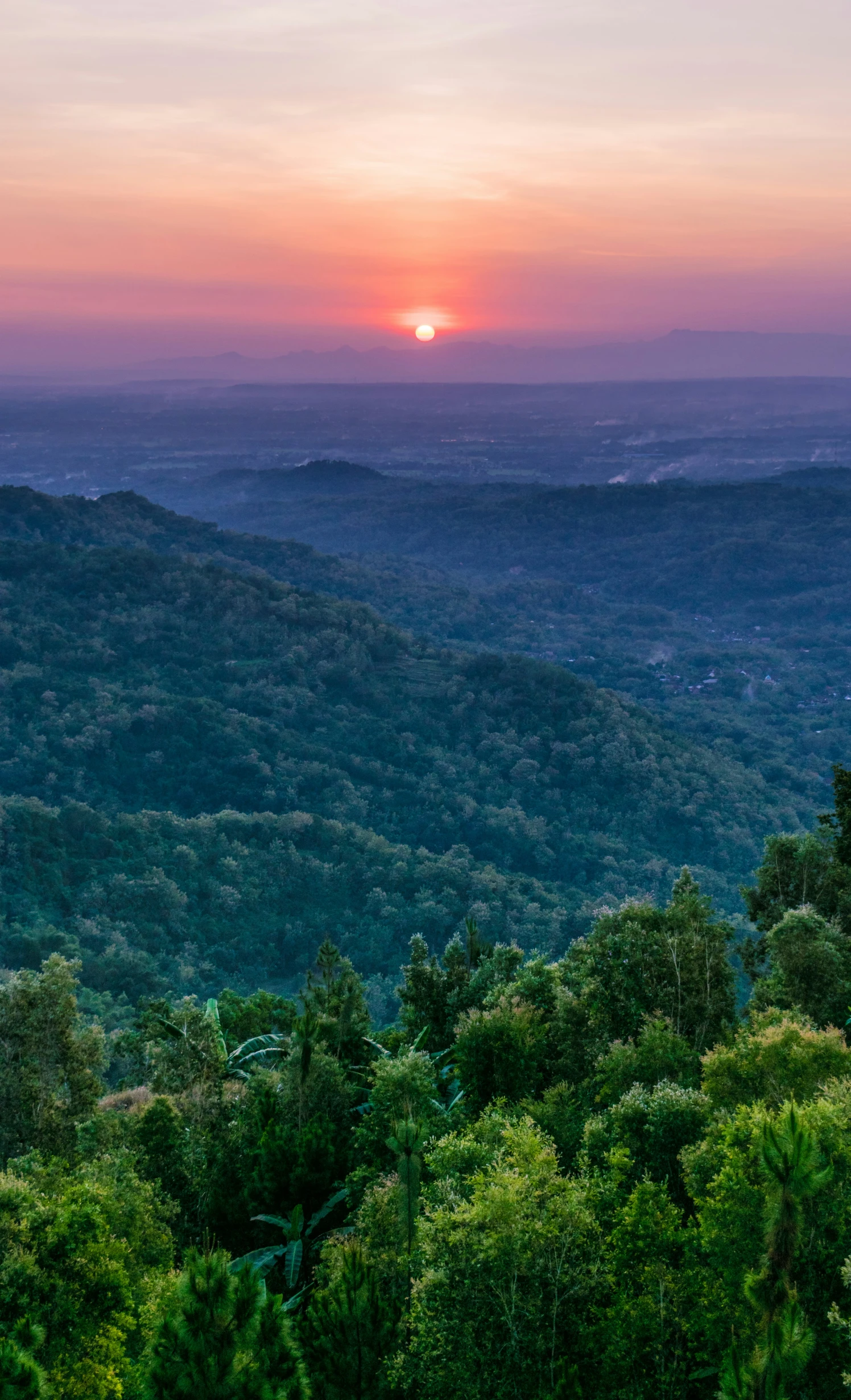 the sun is setting over the mountains that surround