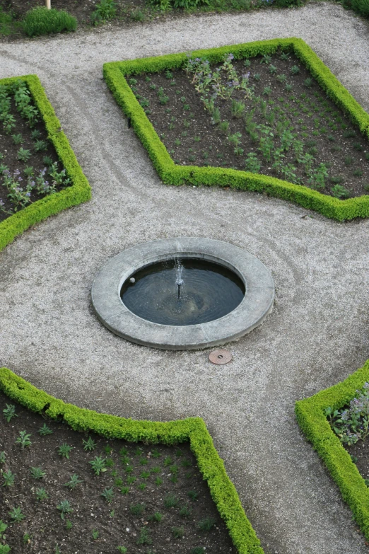 a large planter with a fountain surrounded by grass