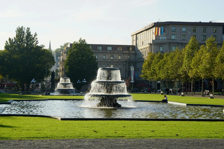 a water fountain is in the middle of a green field