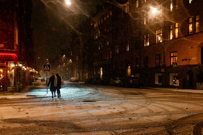 an old fashioned street at night with people walking on it