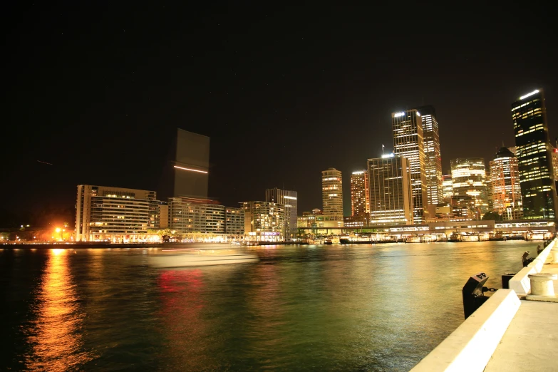 a body of water with buildings at night