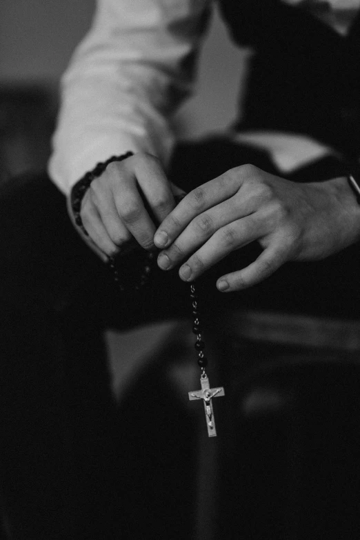 black and white image of man holding cross with both hands