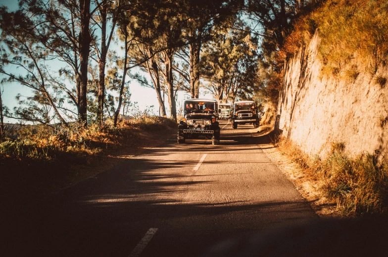 two trucks parked on the side of a narrow road