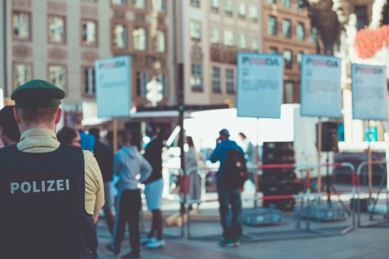 several people stand on a street with security guard