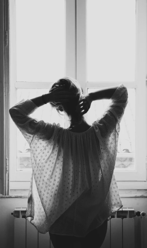 a woman stands behind the window and poses for a po