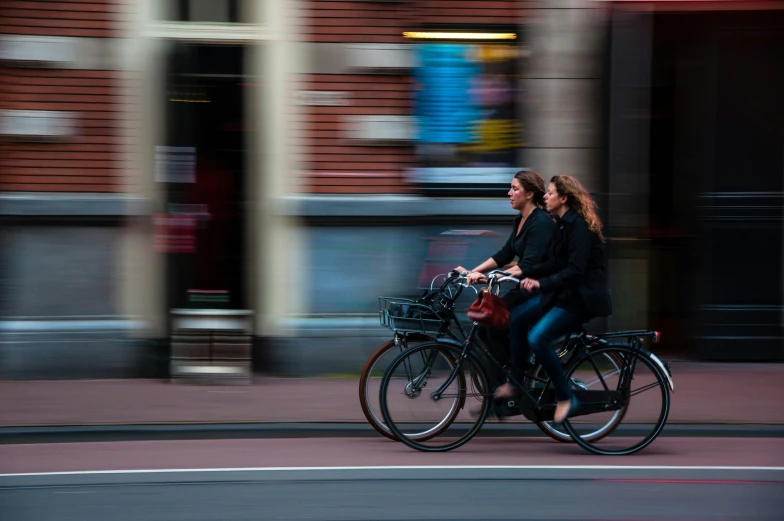 a couple of women on bikes that are crossing a road