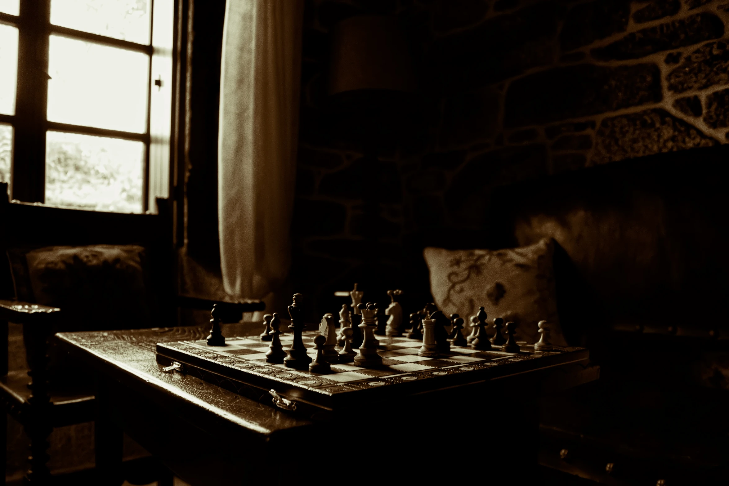 black and white po of chess set next to a chair