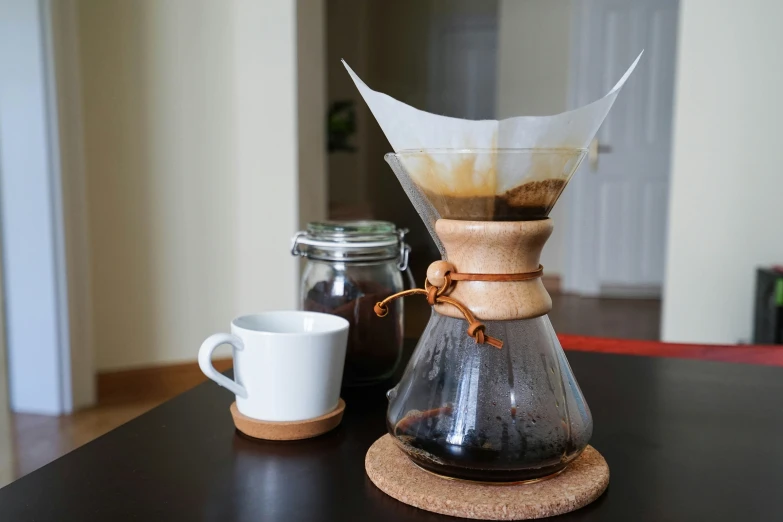 a wooden table with coffee being made into pouro pots