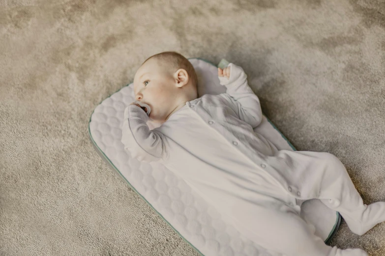 a newborn baby in a blanket with his head on his chest