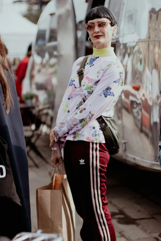 woman in white sweatshirt and red jeans with brown bags