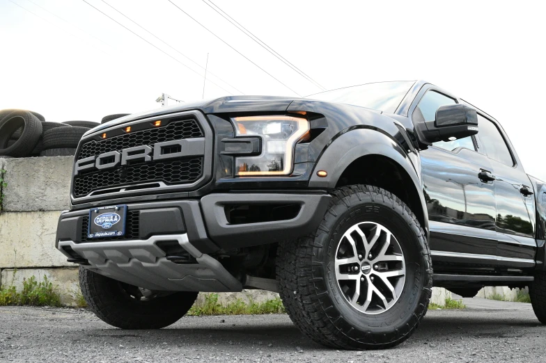 black pickup truck parked in parking lot next to a cement wall