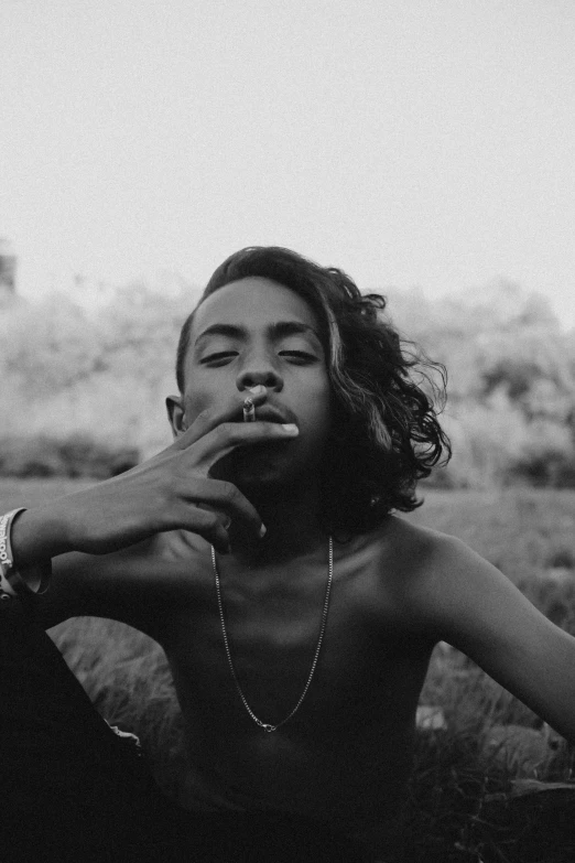 a black woman sitting in a field with mountains in the background