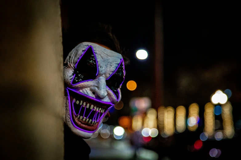 a person wearing a skeleton mask and red neon light