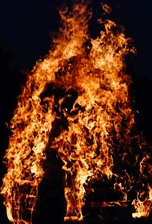 the person is standing in front of a fire