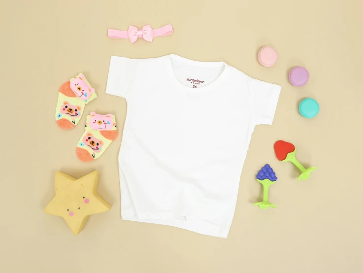 a childs white t shirt with pastel toys next to it