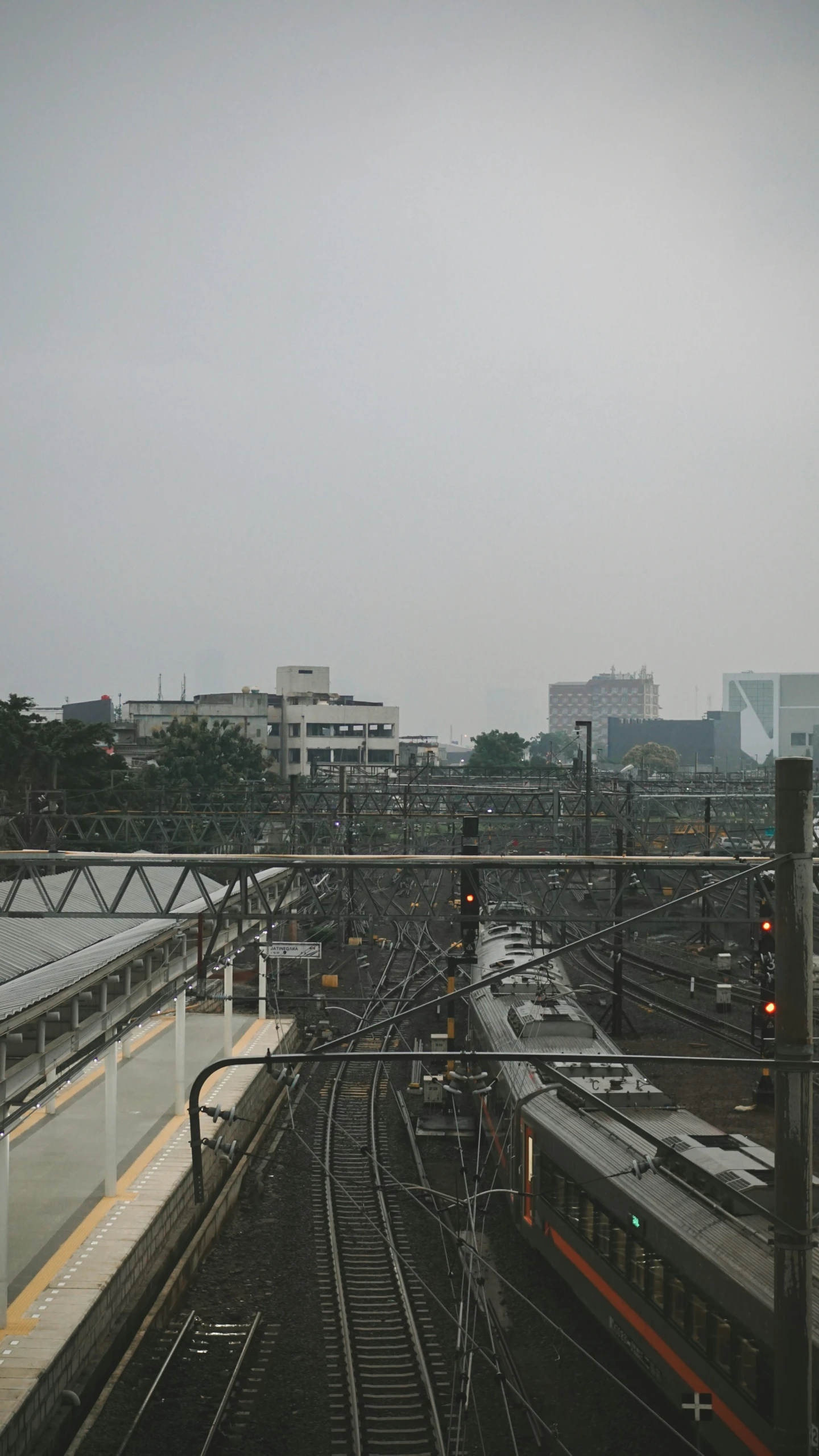 train tracks lead into the city as a sky scs by