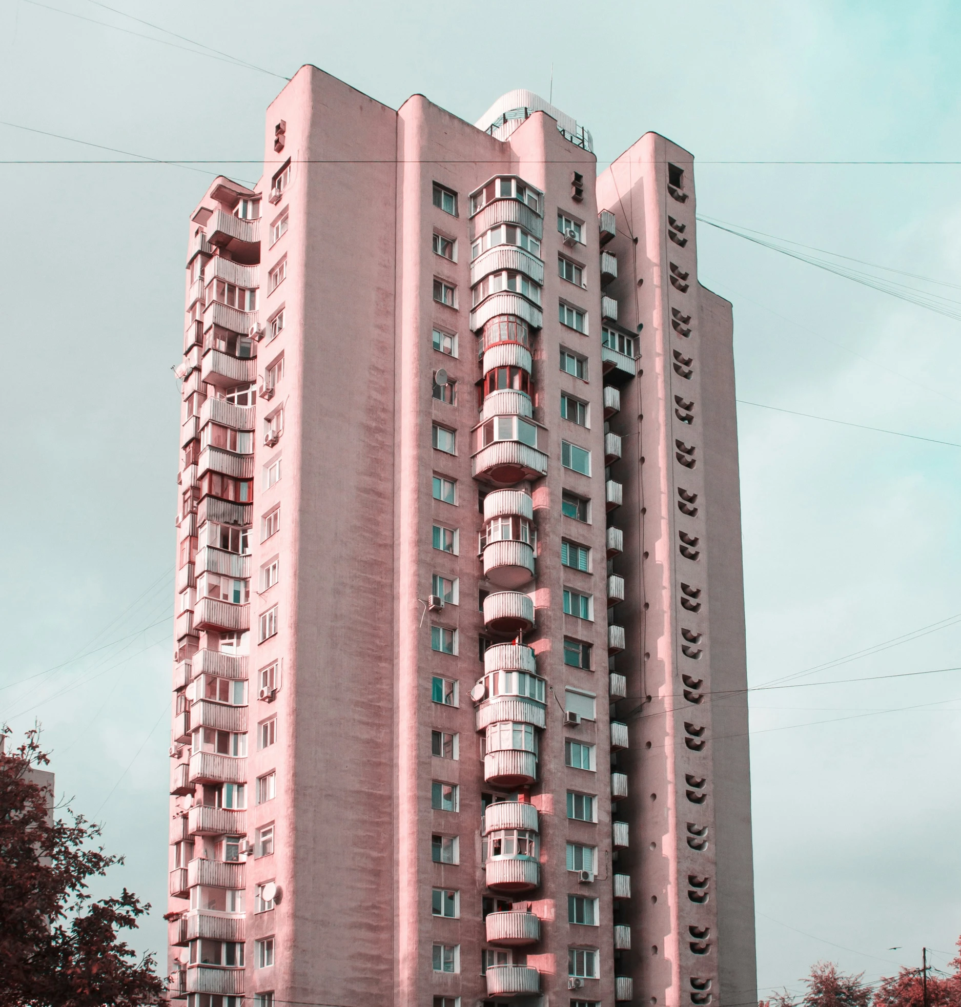 the pink building has balconies on top of it