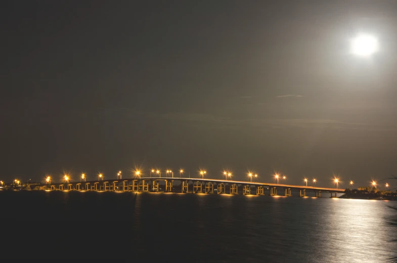 a long bridge at night, lit up by lights
