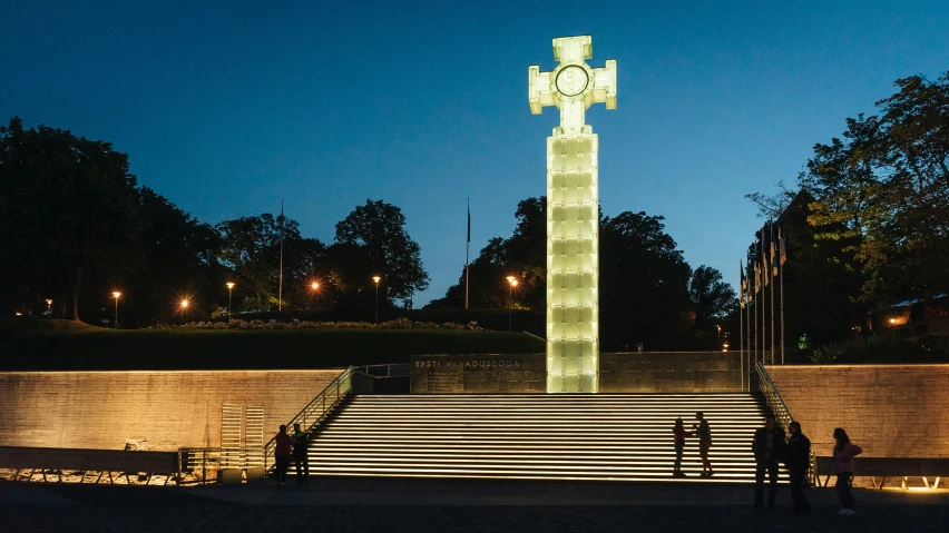 the clock is sitting alone at night in the park