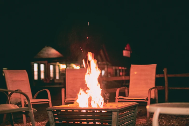 a fire pit in front of chairs and building