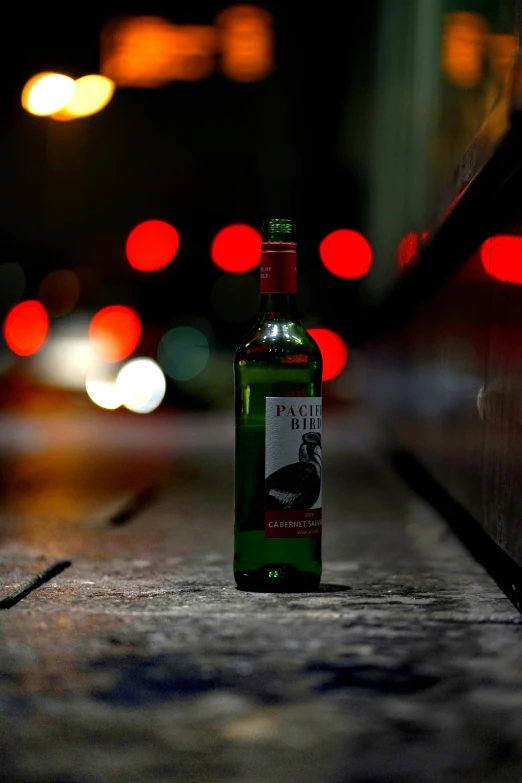 a bottle of alcohol sitting on top of a sidewalk