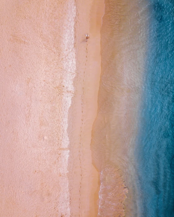 a man standing on top of a beach next to a large body of water