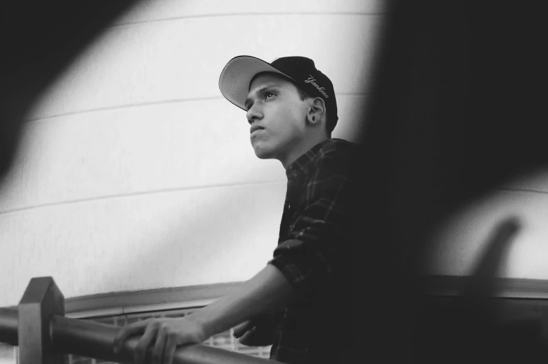 a man in baseball cap looking off into distance