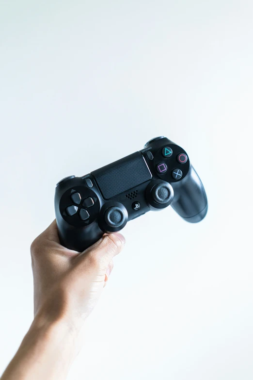 a person holding up a game controller in their hand