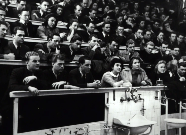 a crowd of people in a stadium looking at the television